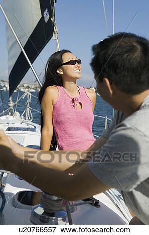Stock Photo - Man and woman on sailboat. Fotosearch