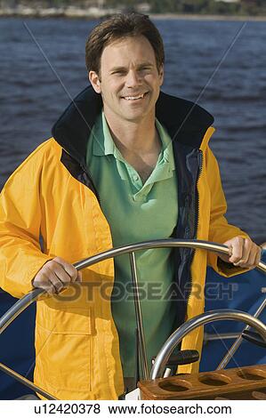 Man at helm of sailboat, (portrait) View Large Photo Image Stock Photo - Man at helm of sailboat, (portrait). Fotosearch
