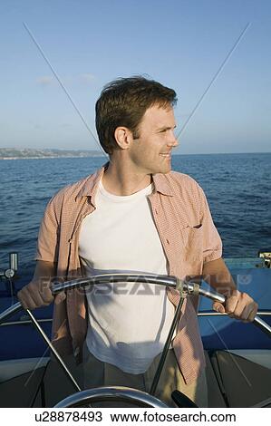Man at helm of sailboat View Large Photo Image Stock Image - Man at helm of sailboat. Fotosearch
