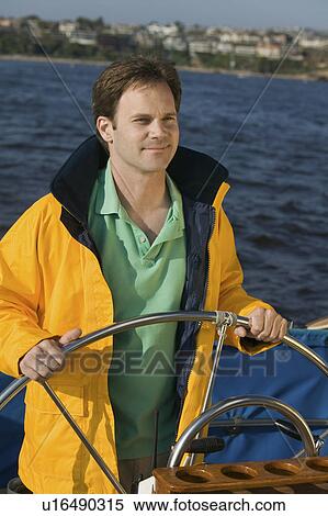 Man at helm of sailboat View Large Photo Image Stock Photography - Man at helm of sailboat. Fotosearch