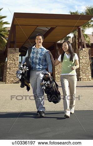Man Carrying Girlfriend's Golf Clubs outside of golf clubhouse View Large Photo Image Stock Photo - Man Carrying Girlfriend's Golf Clubs outside of golf clubhouse. Fotosearch