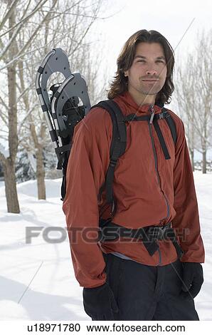 Man carrying snowshoes in snow, portrait. View Large Photo Image Stock Image - Man carrying snowshoes in snow, portrait.. Fotosearch
