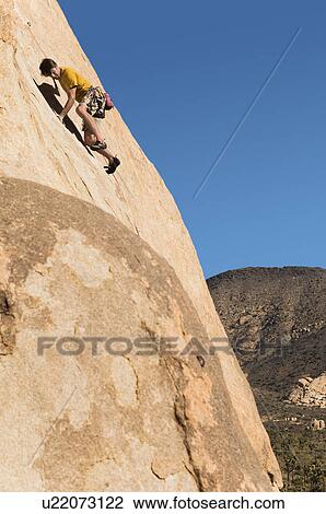 Stock Image - Man Climbing on Cliff. Fotosearch