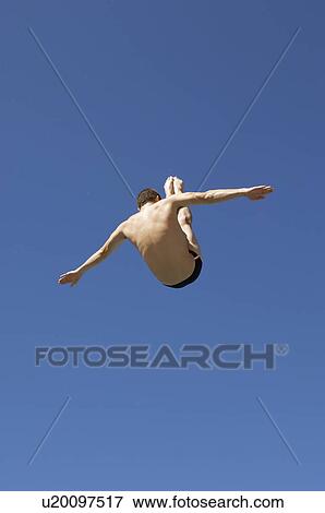 Stock Photo - Man diving in pike position, mid air. Fotosearch