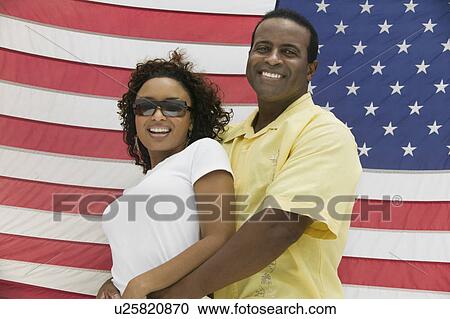 Man embracing woman, American flag in background, (portrait), (low angle view) View Large Photo Image Stock Image - Man embracing woman, American flag in background, (portrait), (low angle view). Fotosearch