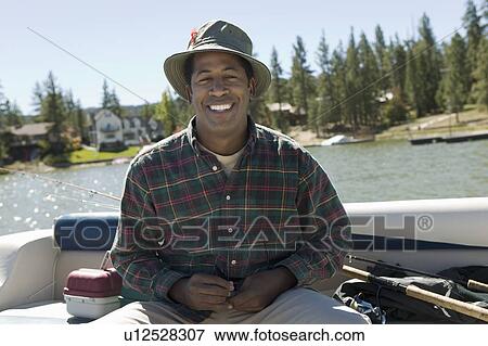 Stock Photo - Man fly fishing on lake, (portrait). Fotosearch