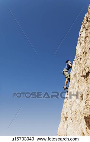 Man Free Climbing on Cliff, side view View Large Photo Image Stock Photo - Man Free Climbing on Cliff, side view. Fotosearch