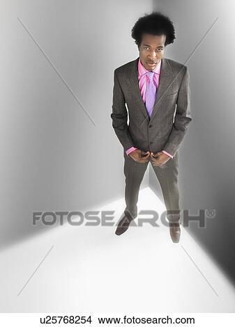 Man in suit in corner of room, elevated view View Large Photo Image Picture - Man in suit in corner of room, elevated view. Fotosearch