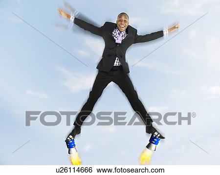 Stock Photograph - Man in suit jumping in star shape with rockets on feet, digital composite. Fotosearch