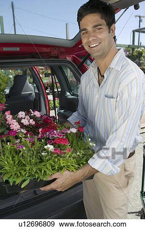 Man Loading Flowers into back of Van, portrait View Large Photo Image Stock Photo - Man Loading Flowers into back of Van, portrait. Fotosearch