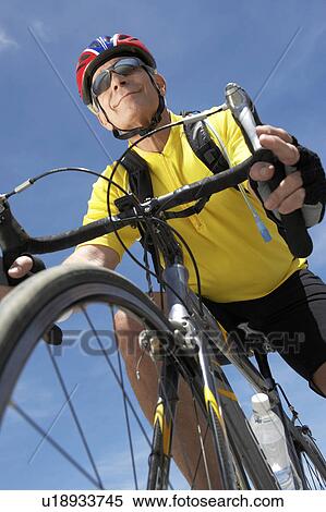 Stock Photography - Man on bicycle ride, low angle view. Fotosearch