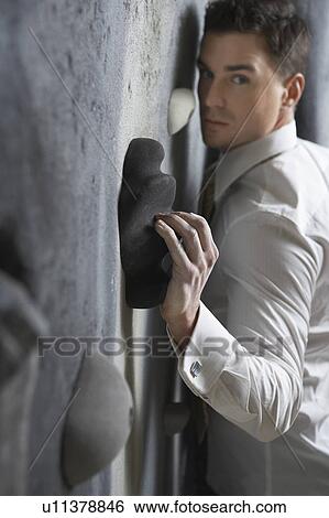 Stock Photograph - Man pressing against climbing wall. Fotosearch