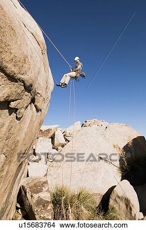 Man Rappelling on Cliff, side view View Large Photo Image Picture - Man Rappelling on Cliff, side view. Fotosearch
