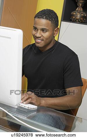 Stock Photo - Man sitting at computer. Fotosearch