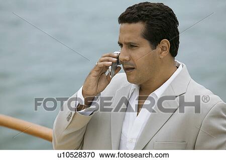 Man talking on mobile phone on boat View Large Photo Image Stock Image - Man talking on mobile phone on boat. Fotosearch