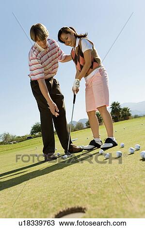 Man teaching teenage girl to putt View Large Photo Image Stock Image - Man teaching teenage girl to putt. Fotosearch