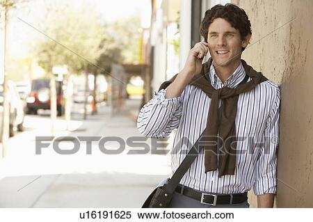 Stock Photography - Man using mobile phone in street. Fotosearch