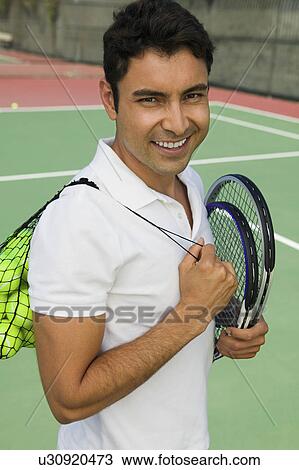 Man with tennis racket and balls on tennis court, portrait View Large Photo Image Stock Image - Man with tennis racket and balls on tennis court, portrait. Fotosearch