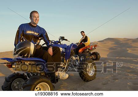Men standing by quad bikes in desert View Large Photo Image Stock Photograph - Men standing by quad bikes in desert. Fotosearch