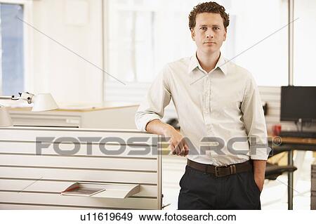 Mid-adult male office worker standing by cubicle, portrait View Large Photo Image Stock Photo - Mid-adult male office worker standing by cubicle, portrait. Fotosearch