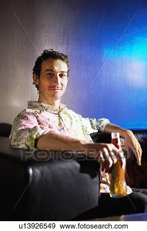 Mid-adult Man sitting in stylish chair, holding beer, portrait View Large Photo Image Stock Photo - Mid-adult Man sitting in stylish chair, holding beer, portrait. Fotosearch