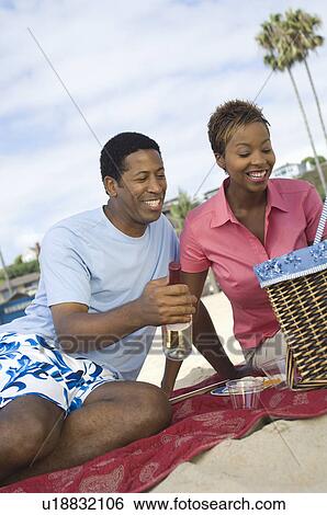 Middle-aged couple having picnic on beach View Large Photo Image Stock Photograph - Middle-aged couple having picnic on beach. Fotosearch