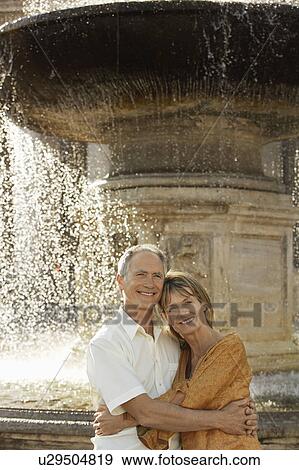 Middle-aged couple hugging by fountain, Rome, Italy, portrait View Large Photo Image Stock Photo - Middle-aged couple hugging by fountain, Rome, Italy, portrait. Fotosearch