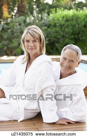 Middle-aged couple in bath robes sitting by pool, portrait View Large Photo Image Stock Photography - Middle-aged couple in bath robes sitting by pool, portrait. Fotosearch
