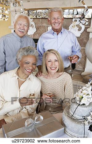 Middle-aged Friends drinking champagne and Celebrating Together View Large Photo Image Stock Image - Middle-aged Friends drinking champagne and Celebrating Together. Fotosearch