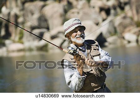 Stock Photo - Middle-aged man fly fishing. Fotosearch