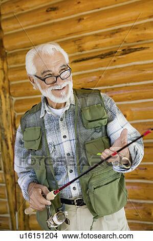 Middle-aged man holding fishing rod, smiling View Large Photo Image Picture - Middle-aged man holding fishing rod, smiling. Fotosearch