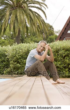 Middle-aged man sitting by pool, portrait View Large Photo Image Stock Photography - Middle-aged man sitting by pool, portrait. Fotosearch