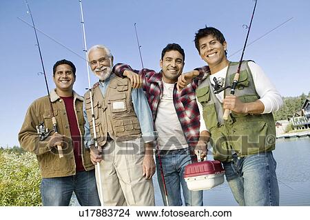 Middle-aged man with three sons holding fishing rods, smiling, (portrait) View Large Photo Image Picture - Middle-aged man with three sons holding fishing rods, smiling, (portrait). Fotosearch