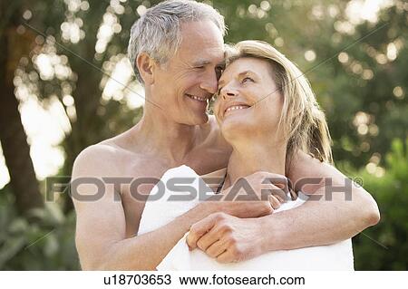 Middle-aged man wrapping partner in towel outdoors View Large Photo Image Stock Image - Middle-aged man wrapping partner in towel outdoors. Fotosearch