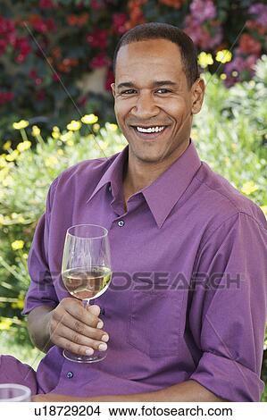 Middle aged sitting, holding wine glass, outdoors View Large Photo Image Picture - Middle aged sitting, holding wine glass, outdoors. Fotosearch