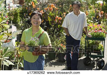 Middle-aged woman standing in plant nursery, portrait View Large Photo Image Stock Image - Middle-aged woman standing in plant nursery, portrait. Fotosearch