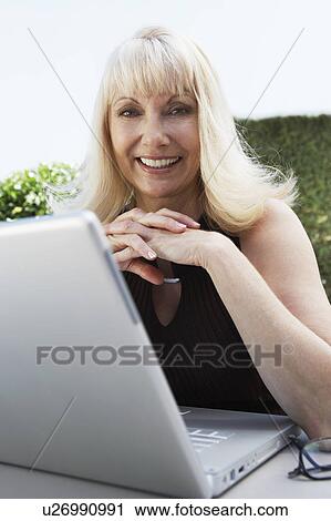 Middle aged woman Using Laptop in Garden View Large Photo Image Stock Image - Middle aged woman Using Laptop in Garden. Fotosearch