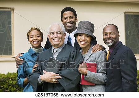 Stock Photo - Minister with Family in church garden, portrait. Fotosearch