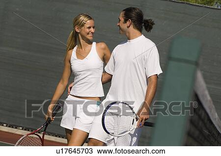 Stock Image - Mixed Doubles Partners standing on Court, arms around. Fotosearch