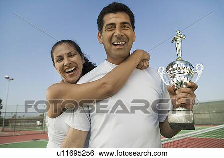 Mixed doubles Tennis Players standing in tennis court holding trophy, portrait View Large Photo Image Stock Photograph - Mixed doubles Tennis Players standing in tennis court holding trophy, portrait. Fotosearch