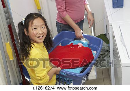 Picture - Mother and daughter (7-9) doing laundry. Fotosearch