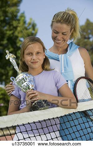 Mother and Daughter at Tennis Net with Trophy, portrait View Large Photo Image Stock Image - Mother and Daughter at Tennis Net with Trophy, portrait. Fotosearch
