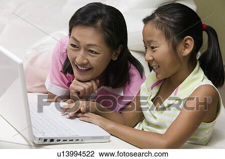 Mother and Daughter in living room Using Laptop Together View Large Photo Image Stock Image - Mother and Daughter in living room Using Laptop Together. Fotosearch