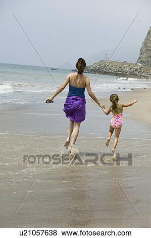 Mother and daughter skipping on beach View Large Photo Image Stock Photo - Mother and daughter skipping on beach. Fotosearch