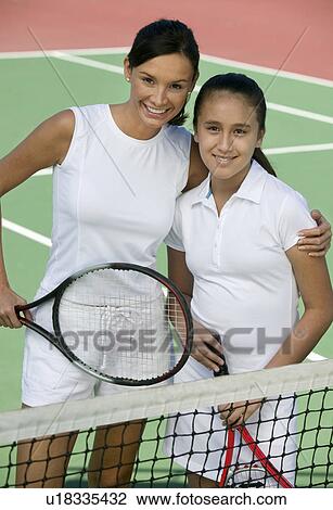 Mother and daughter standing at net on tennis court, portrait, high angle view View Large Photo Image Stock Image - Mother and daughter standing at net on tennis court, portrait, high angle view. Fotosearch
