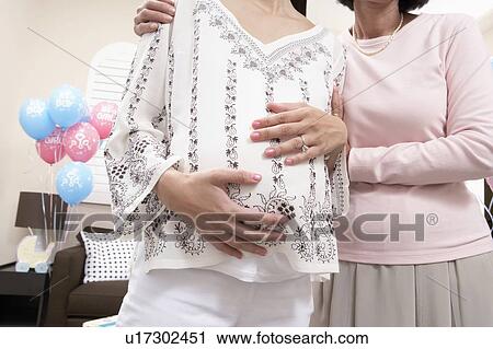 Mother and pregnant daughter at baby shower, mid section View Large Photo Image Stock Image - Mother and pregnant daughter at baby shower, mid section. Fotosearch