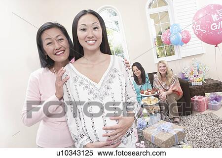 Stock Photography - Mother and pregnant daughter at Baby Shower. Fotosearch