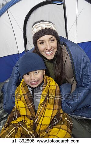 Stock Photograph - Mother and son (7-9) in tent, (portrait). Fotosearch