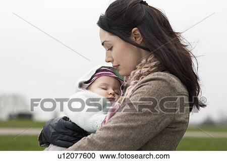 Mother carrying sleeping baby View Large Photo Image Stock Image - Mother carrying sleeping baby. Fotosearch