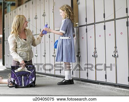 Mother packing daughters school bag near school lockers View Large Photo Image Stock Photography - Mother packing daughters school bag near school lockers. Fotosearch